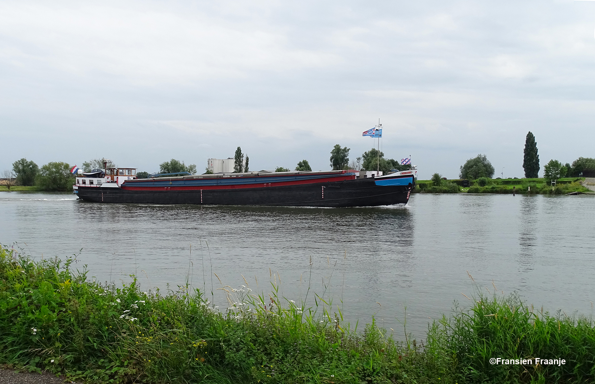 Eenmaal bij de Rijn aangekomen, genieten we van de voorbij varende vrachtschepen. Deze komt uit Friesland, met de eigen vlag voor op de steven - Foto: ©Fransien Fraanje