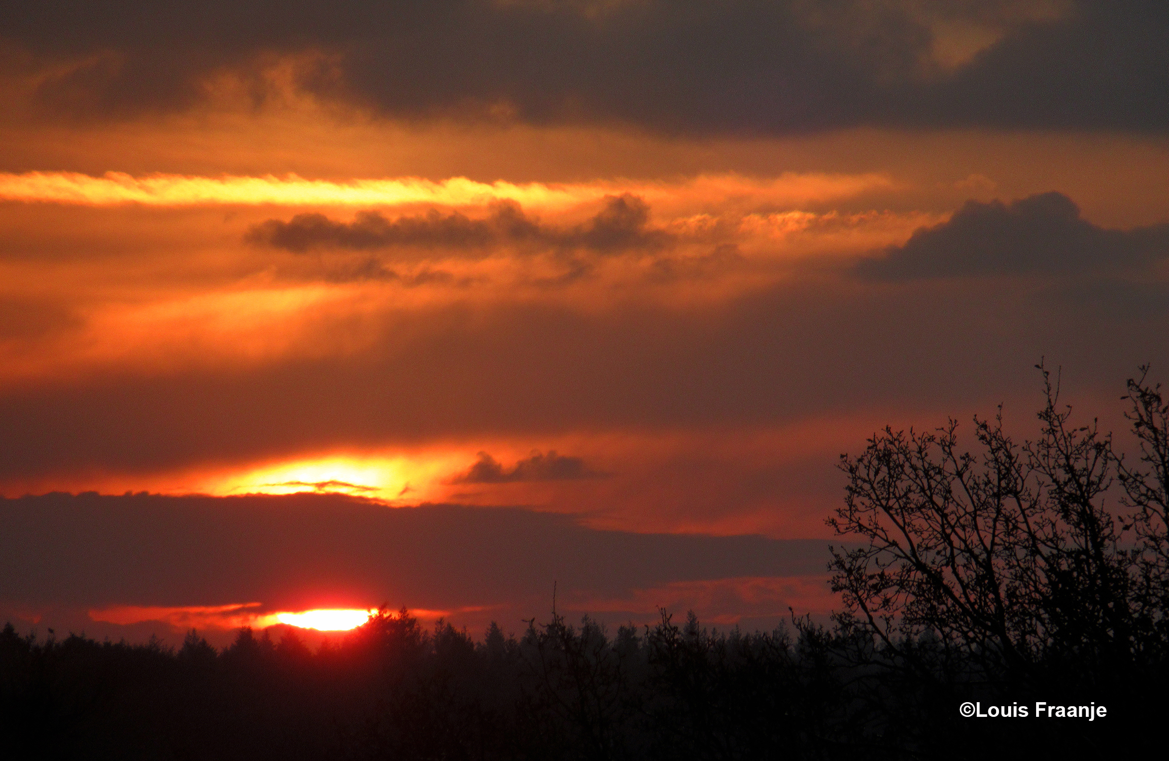 Dwars door de wolkenband verschijnt de morgenzon - Foto; ©Louis Fraanje